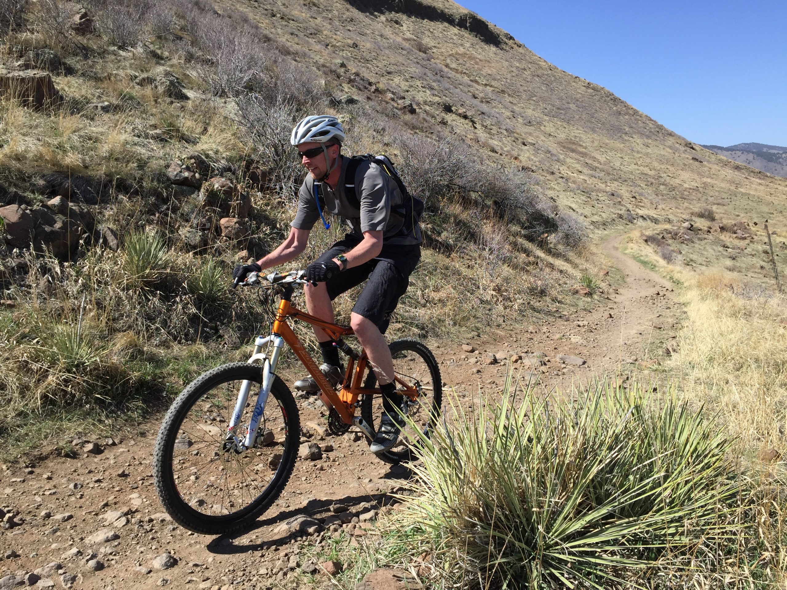 A man mountain biking down a gravel path
