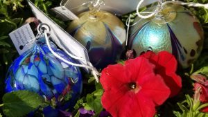 A decorative red flower and three hand blown glass orbs part of the September scavenger hunt in Golden CO 2025 by @shinyspheresearh
