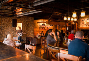 Miners Saloon interior with a guitarist playing music and people eating and drinking