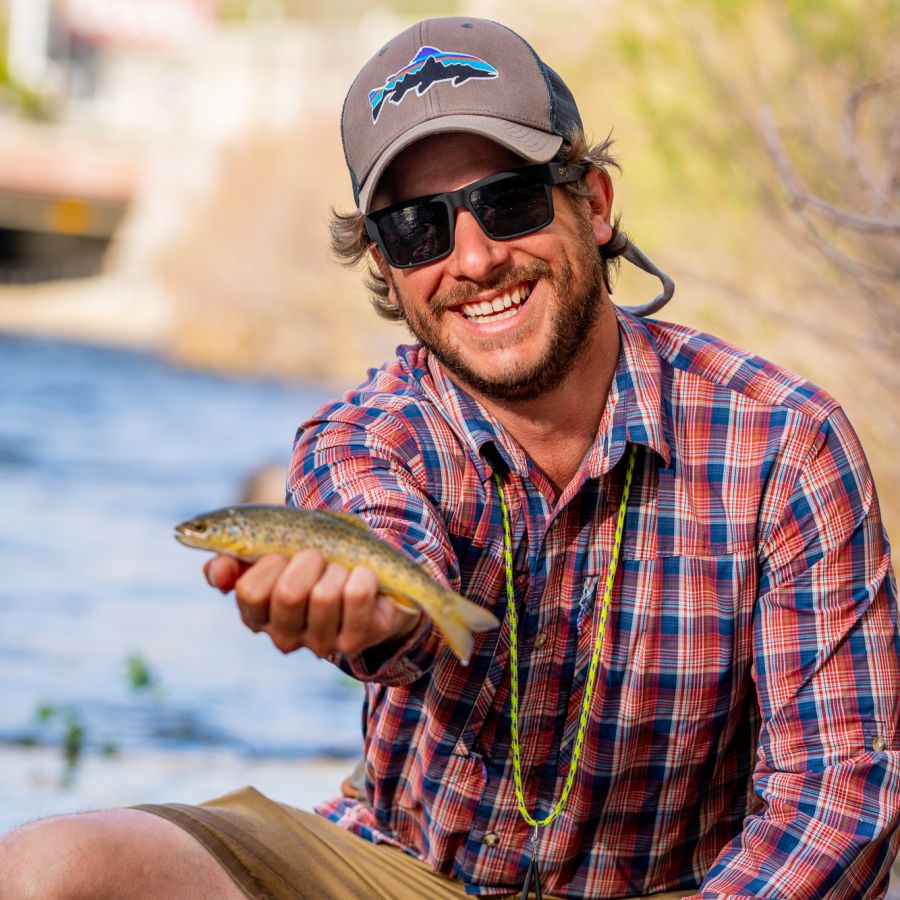 Man holding up a fish he caught in Clear Creek