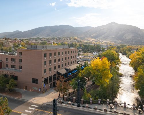 Aerial view of the Golden Hotel along Clear Creek, surrounded by fall foliage and the foothills.