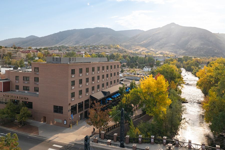 Aerial view of the Golden Hotel along Clear Creek, surrounded by fall foliage and the foothills.