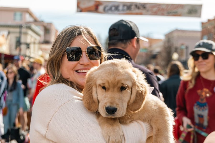 A Goldens In Golden attending holding their Golden Retriever puppy